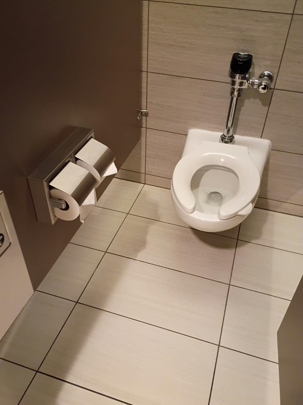 Client-supplied clean tiled restroom with wall-mounted toilet